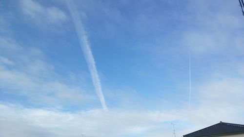 Low angle view of vapor trail against blue sky