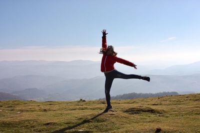 Man standing on field against mountain range