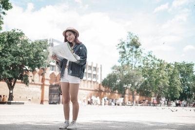 Full length portrait of young woman in park