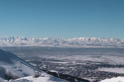 Scenic view of snowcapped mountains against clear blue sky