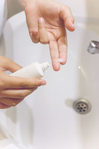 Midsection of child holding hands in bathroom