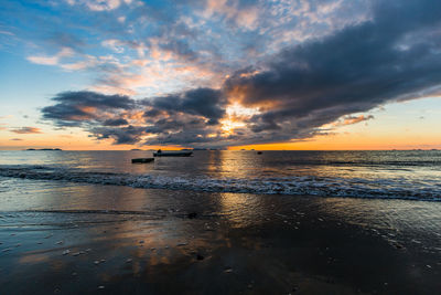 Scenic view of sea against dramatic sky during sunset