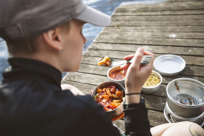 Female hiker having meal at lake