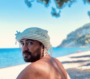 Portrait of young man in sea against sky