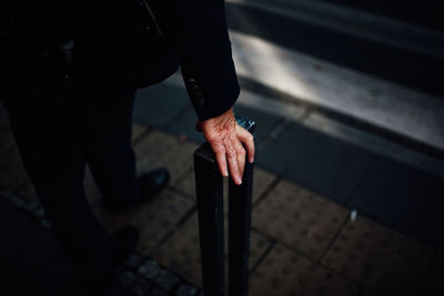 Low section of man holding pole on street