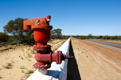 Red truck on road against clear sky