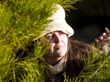 Close-up of woman by branch