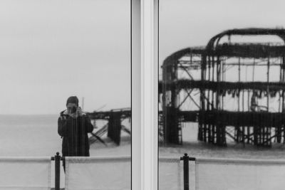 Young woman photographing reflecting on window