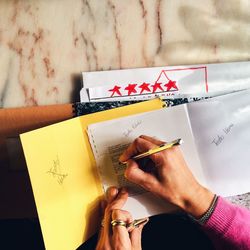 Cropped hand of woman writing on paper