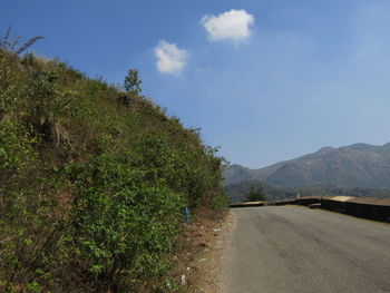 Road amidst trees against sky