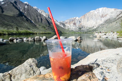 Close-up of ice cream on rock against lake