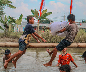 Rear view of boy playing with toy on field