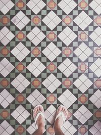 Low section of man standing on tiled floor