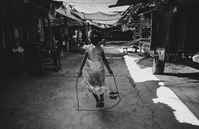 Rear view of woman walking on road