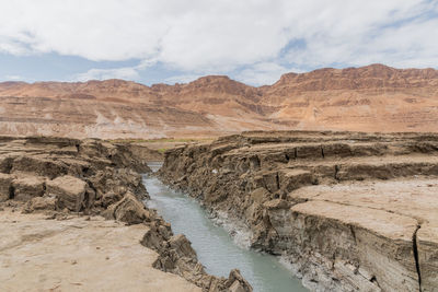 Sinkhole filled with turquoise water, near dead sea coastline. hole formed when underground salt is