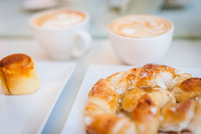 High angle view of dessert with cappuccinos and croissant served on table