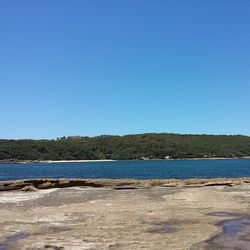 Scenic view of calm lake against clear blue sky