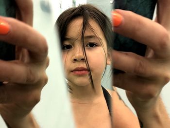 Close-up portrait of girl holding mirror