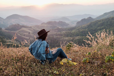 Rear view of man sitting on land