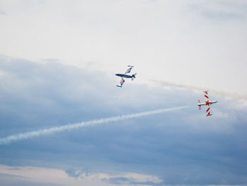 Airplanes flying in cloudy sky