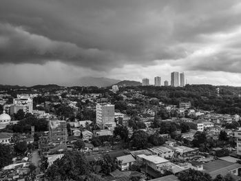 High angle view of buildings in city against storm clouds