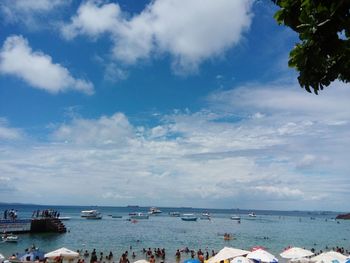 Boats in sea against cloudy sky