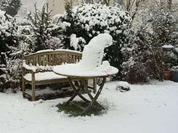 Snow covered bench in park