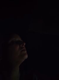 Portrait of young man against black background