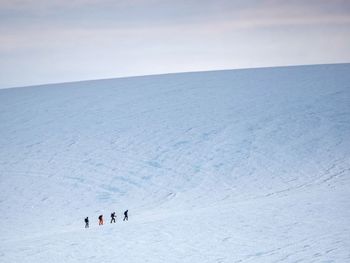 People skiing on snow covered landscape