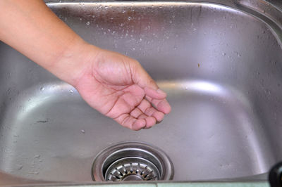Close-up of woman hand over kitchen sink