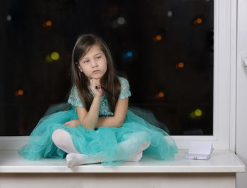 Cute girl sitting on table