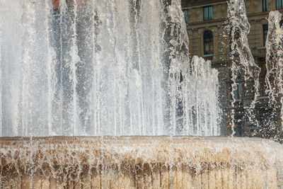 Water splashing on fountain against building