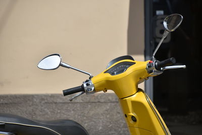 Close-up of yellow scooter on street