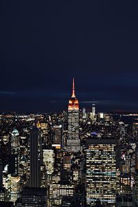 Illuminated buildings in city against sky at night