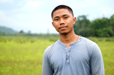 Portrait of young man standing on field