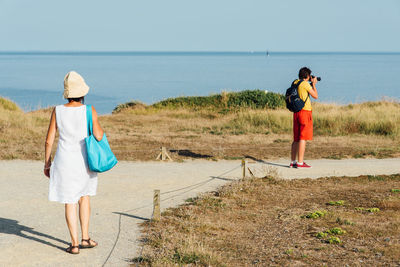 Rear view of women standing on beach