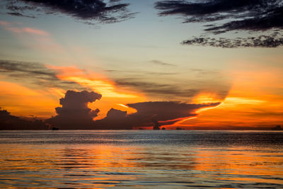 Scenic view of sea against dramatic sky during sunset