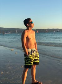Full length of shirtless boy standing on beach