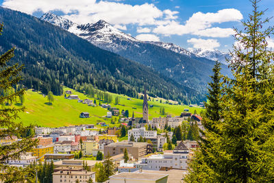 Scenic view of townscape and mountains against sky