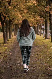 Rear view of woman walking in forest