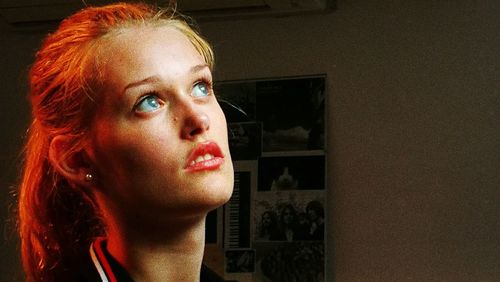 Close-up portrait of young woman looking away at home