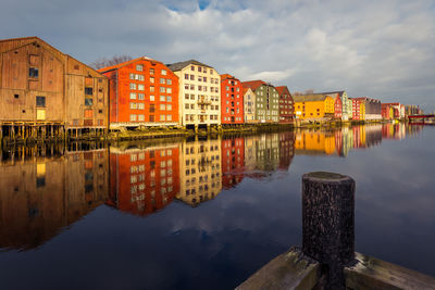 Reflection of buildings in river against sky