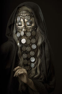 Portrait of woman wearing mask against black background