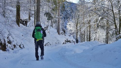 Rear view of man skiing on snow covered landscape