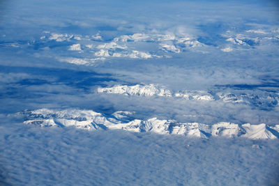 Aerial view of snow covered landscape against sky