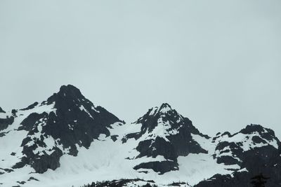 Low angle view of snowcapped mountain against clear sky