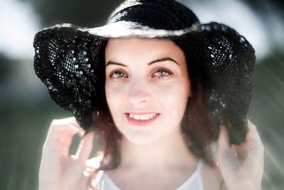 Portrait of smiling young woman wearing hat