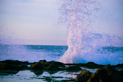 Waves splashing on sea against sky