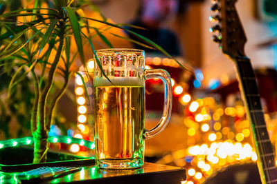 Beer glass on table against lighting decorations