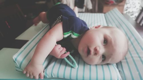 Portrait of cute baby lying on bed at home